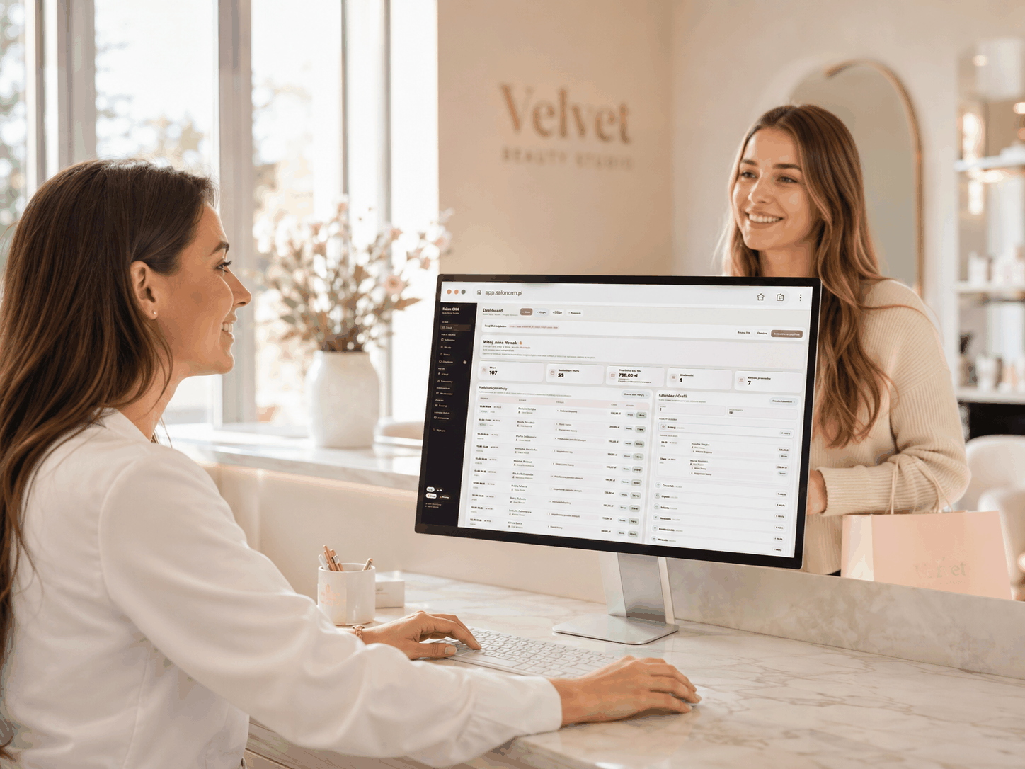 Salon reception desk with a monitor showing the SalonCRM dashboard
